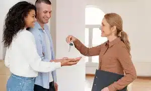 Realtor Handing Keys to Clients. In a safe environment.